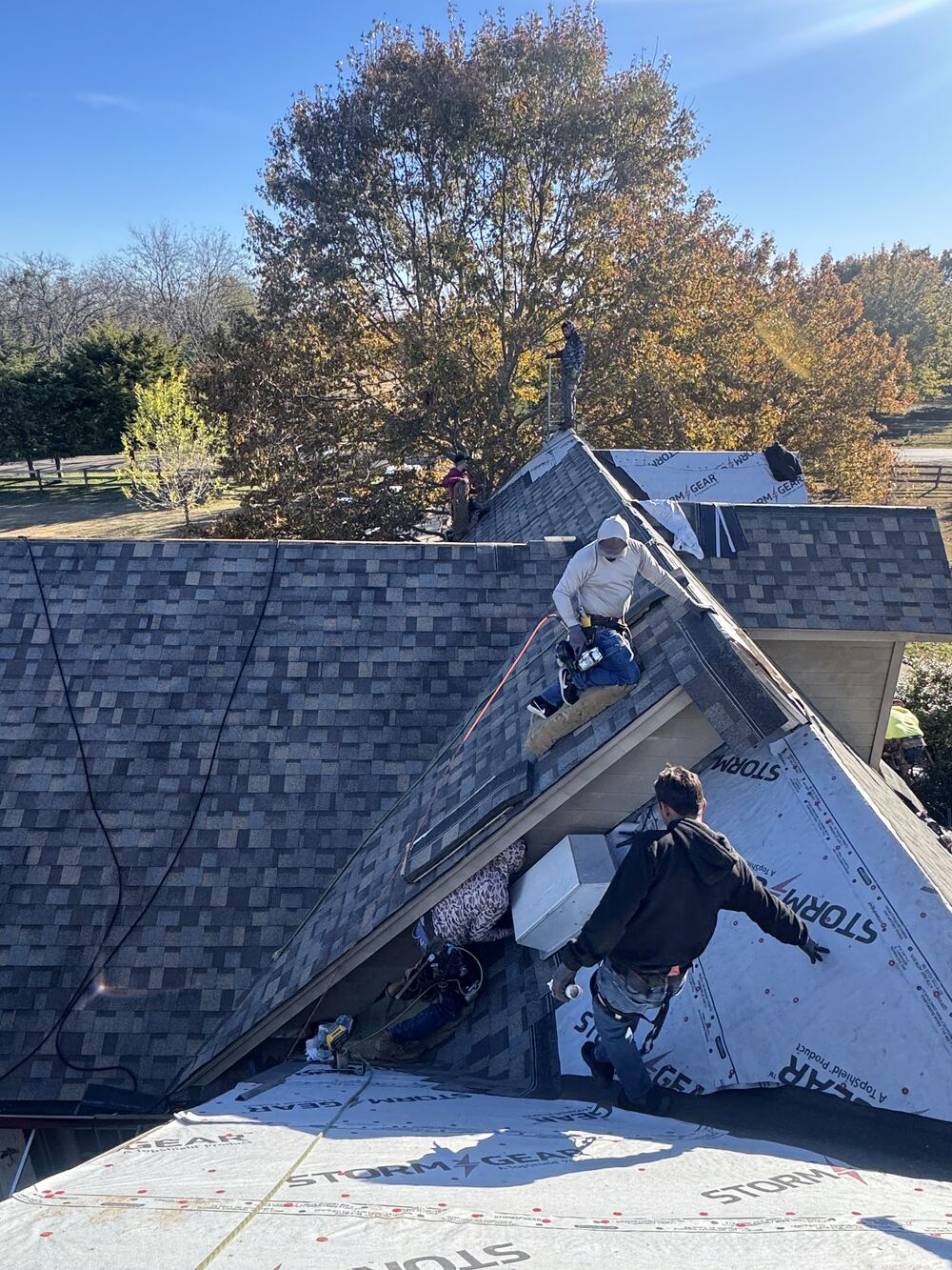 Crew members roped in working on a steep roof pitch
